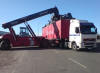 En 35-tons topplyftstruck lossar en 40 fots container frn ett trailerchassi.